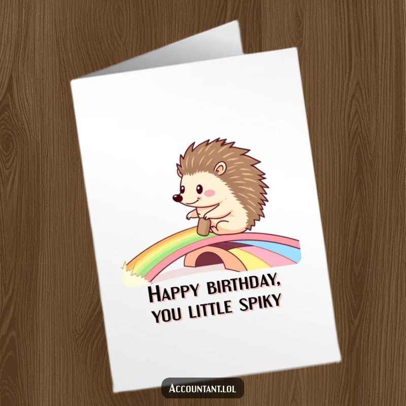 Funny Free Printable Birthday Card: Happy hedgehog rolling a large ledger across a vibrant rainbow bridge, smiling brightly.